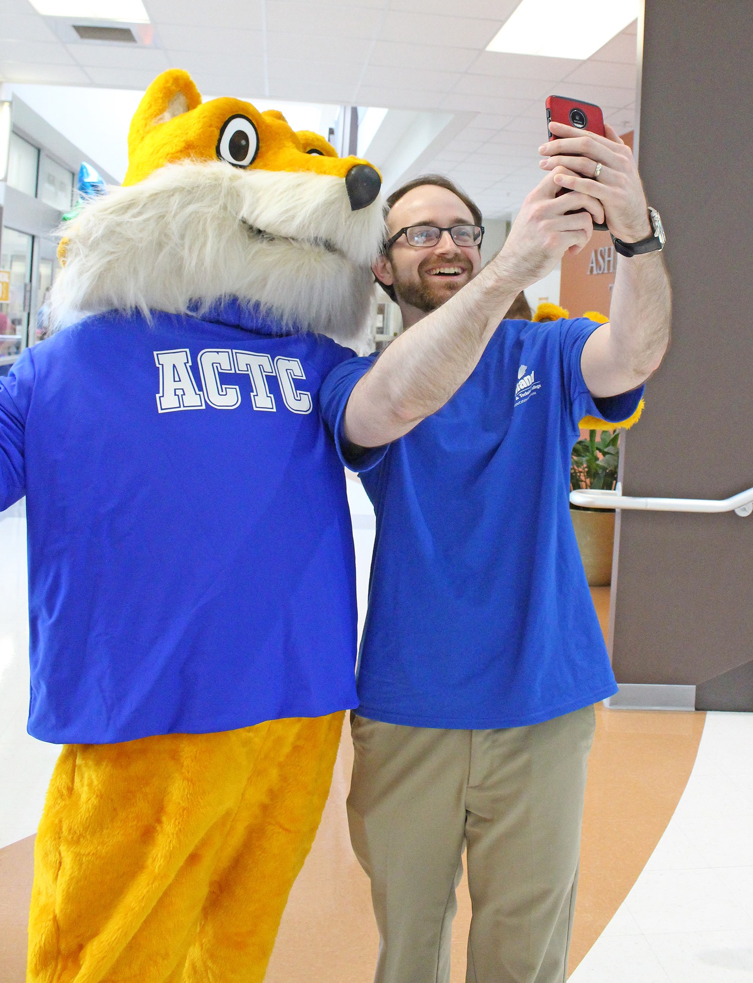Ashland Community and Technical College staff posing for a selfie with the ACTC Pathfinder, the college's mascot
