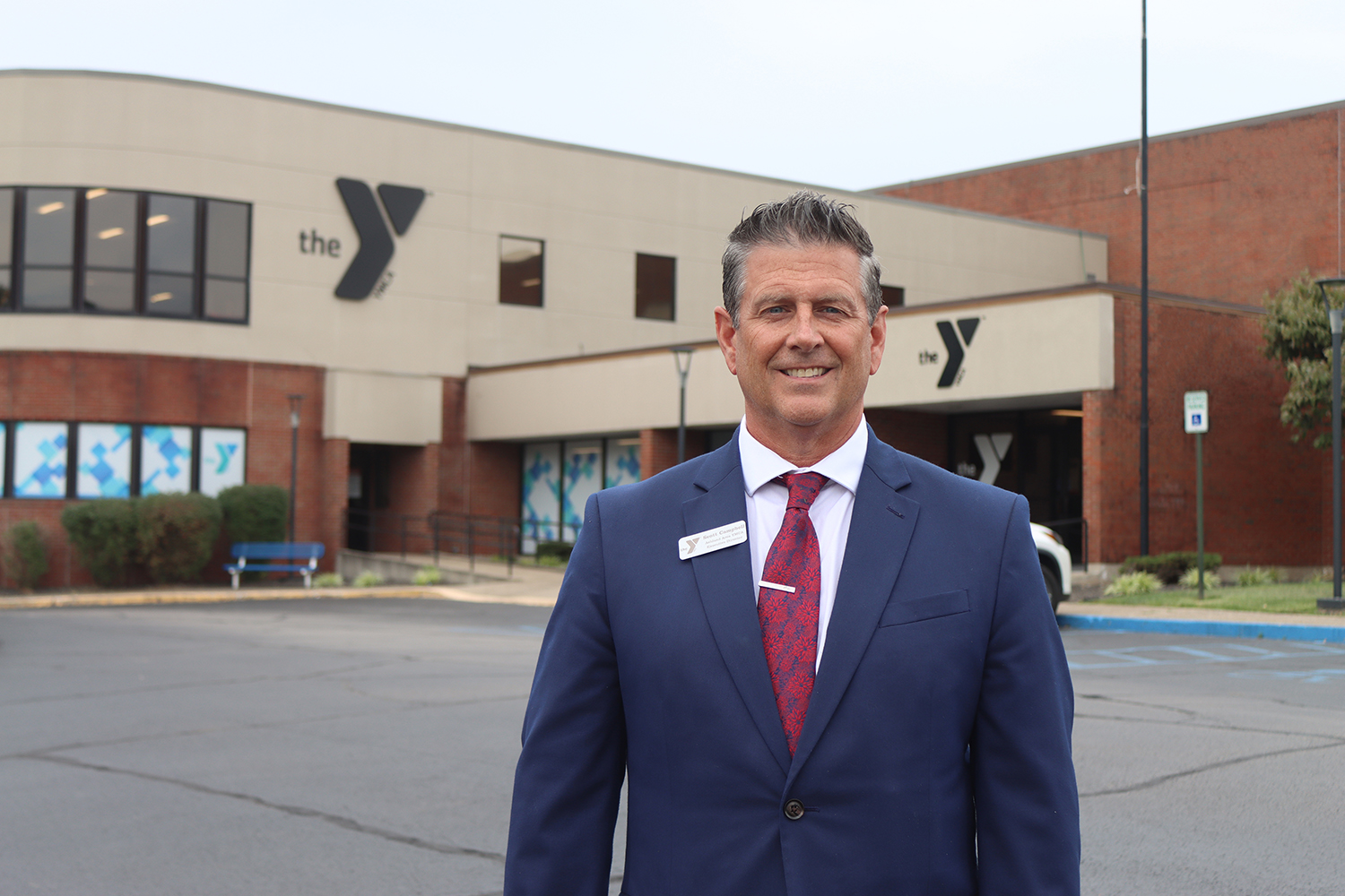 scott-campbell-in-blue-suit-in-front-of-YMCA