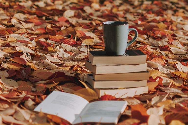 gray mug on top of books