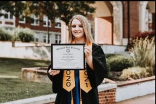 Haleigh Peck in 2020-2021 graduation gown smilling and holding her diploma