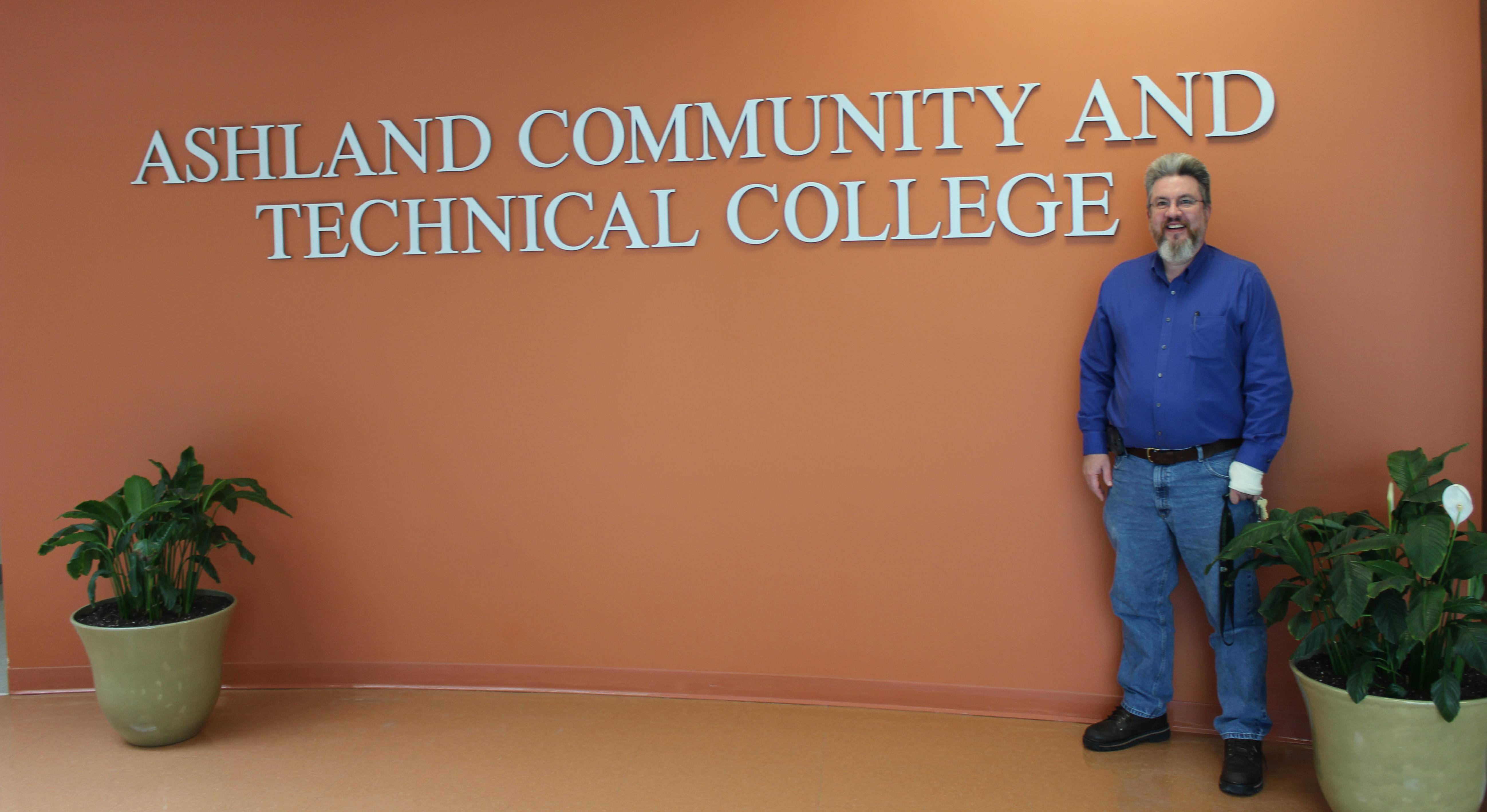  Professor, Program Coordinator of Computer Information Technology, and Advisor David Childress stands in front of the ACTC logo in the foyer on the Technology Drive Campus.