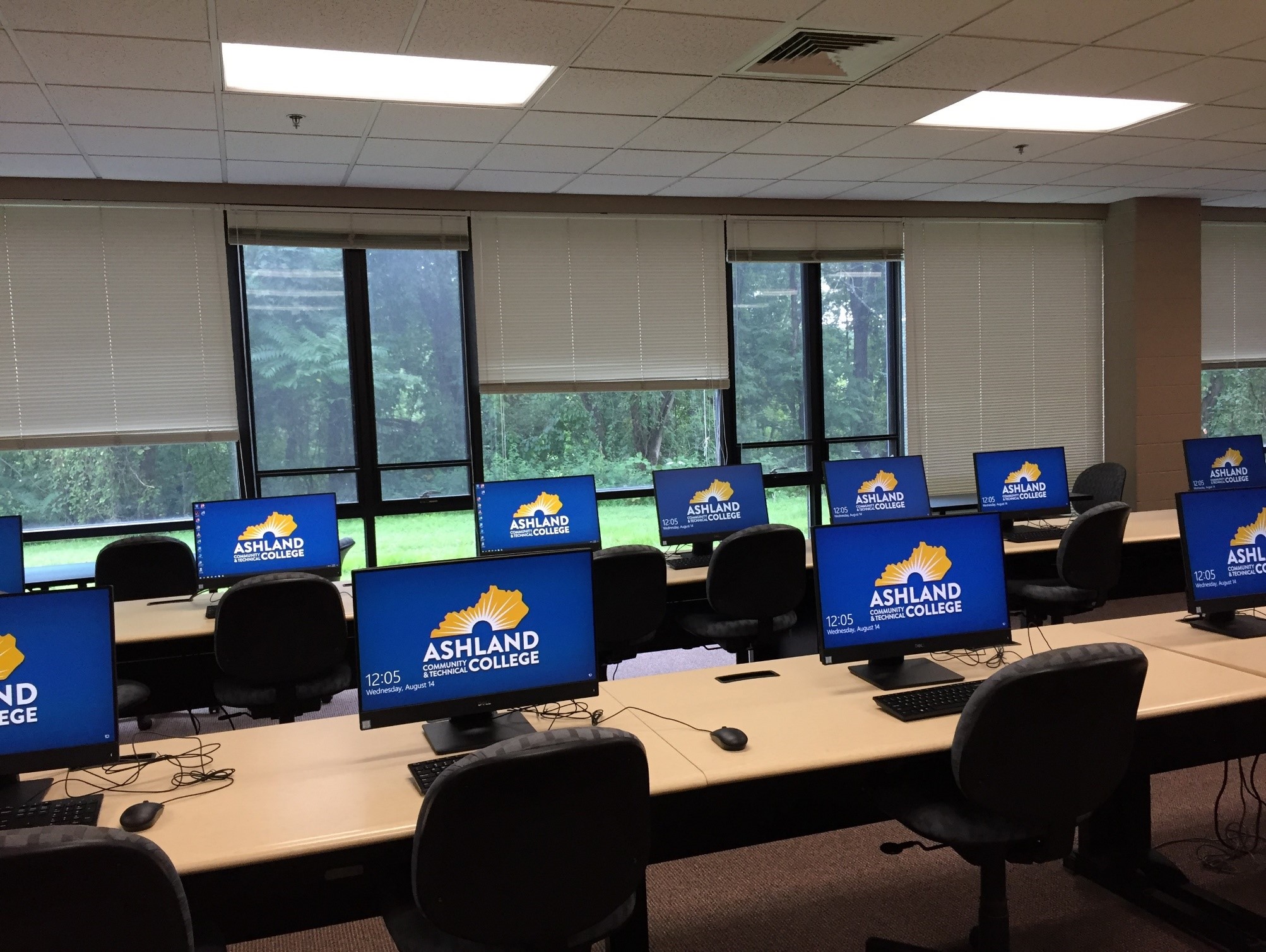 Two rows of computers in the lab with accompanying chairs and desks