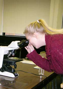  girl looking through microscope