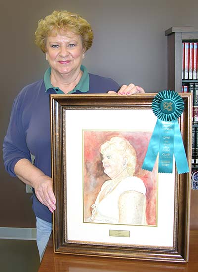 Janet displays her painting and ribbon.