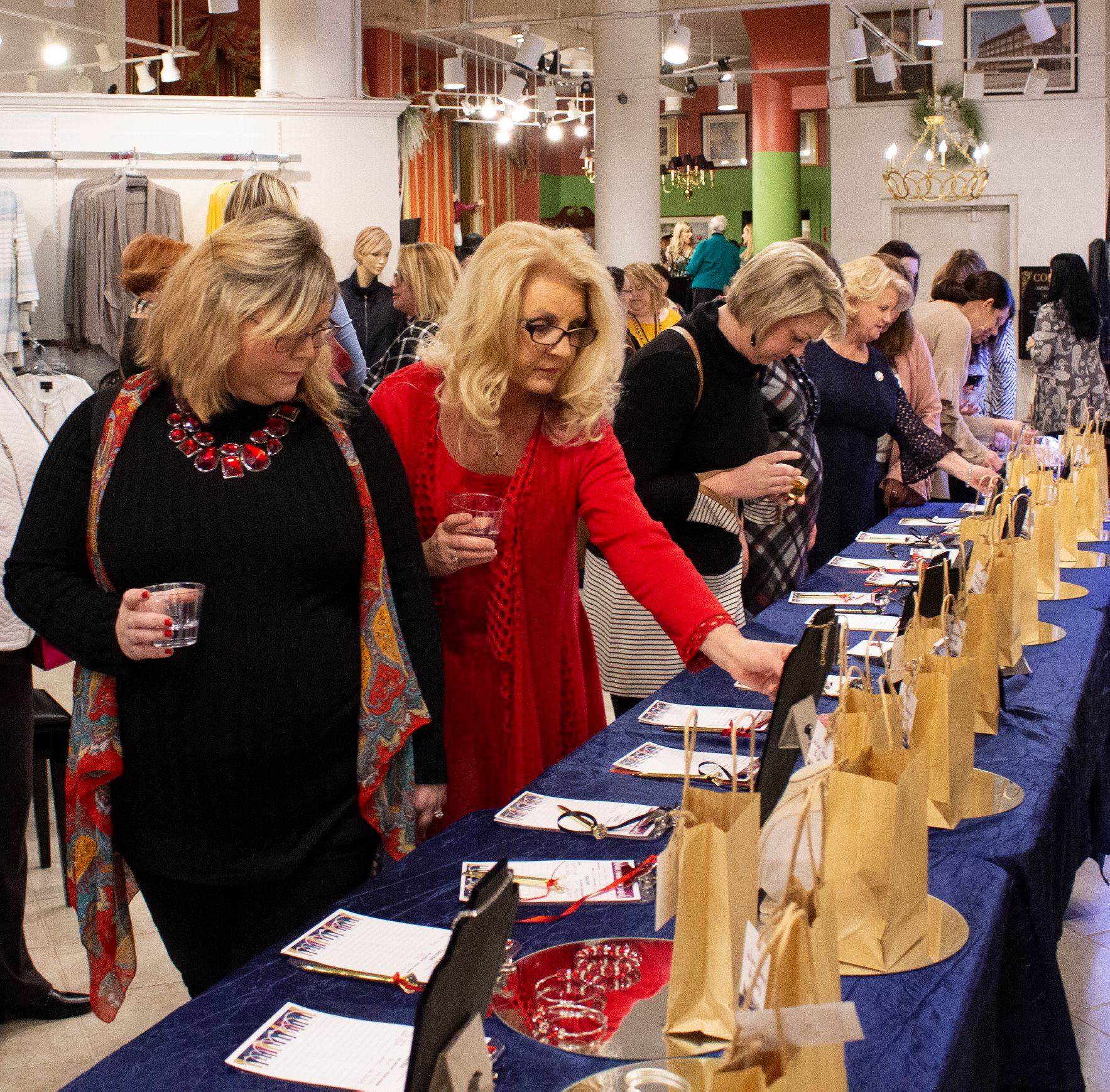 Women look at jewlery items for auction